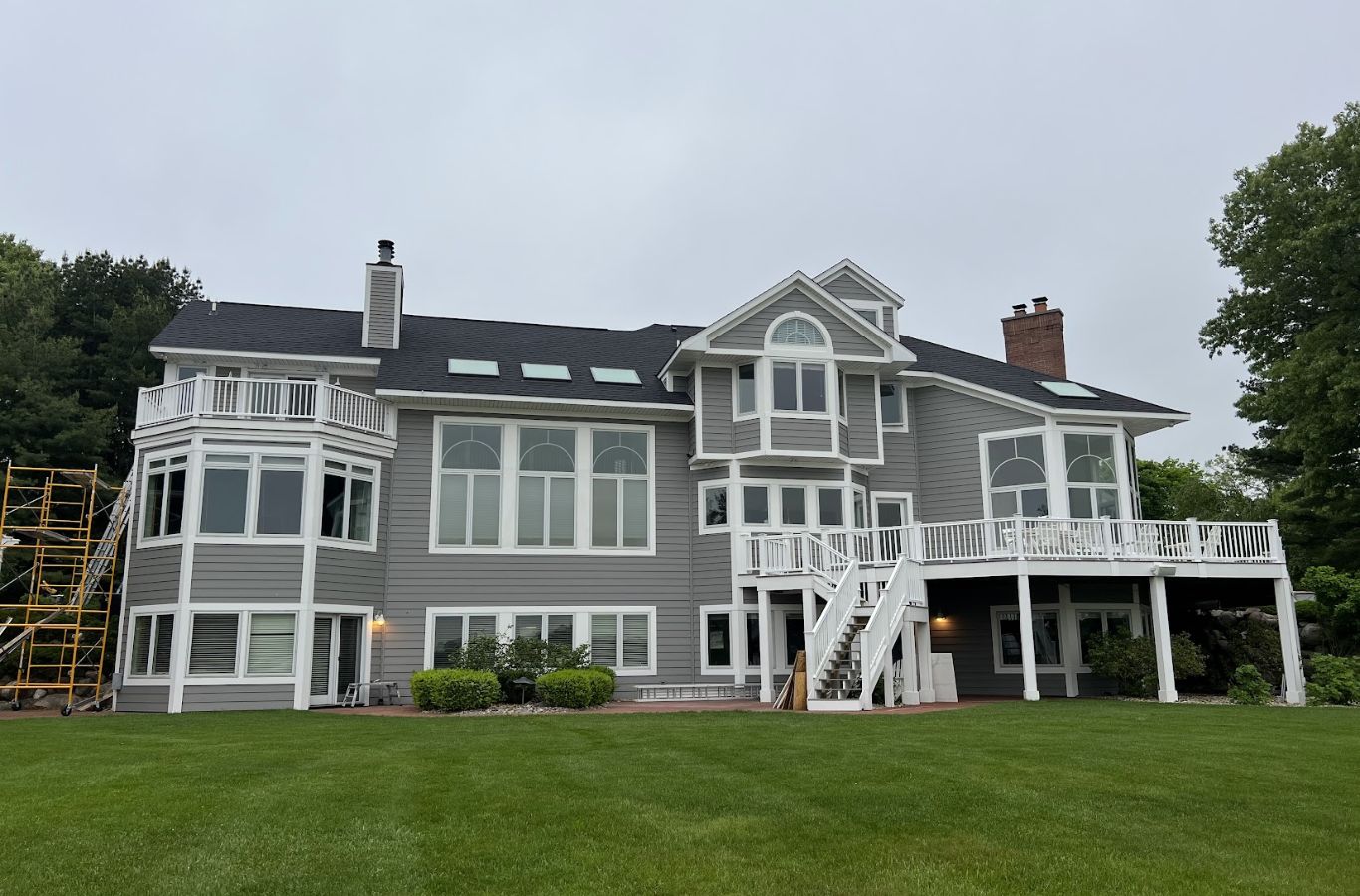 Roof replacement crew in Galesburg, MI aligning shingles carefully along a steep residential ridge