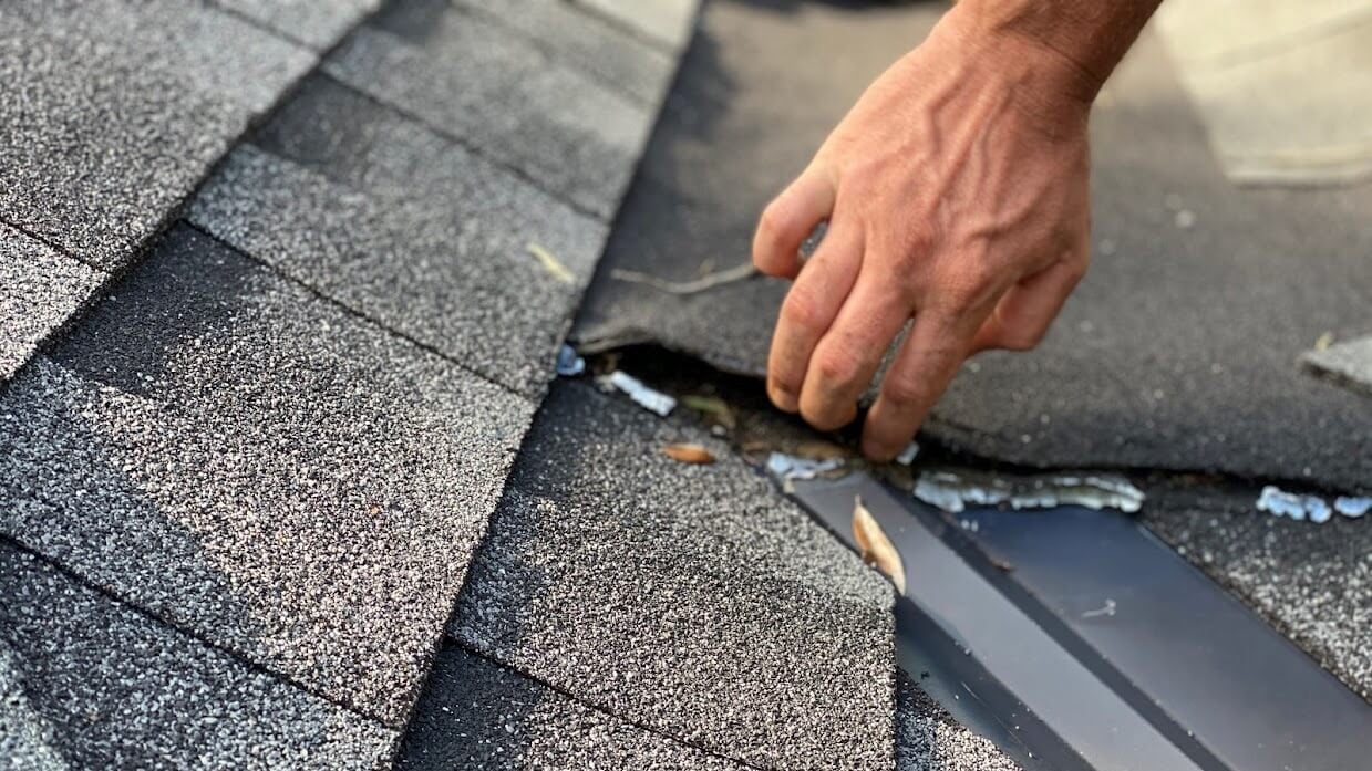 Experienced inspector marking storm damage on Portage, MI composite roof with digital tablet for report